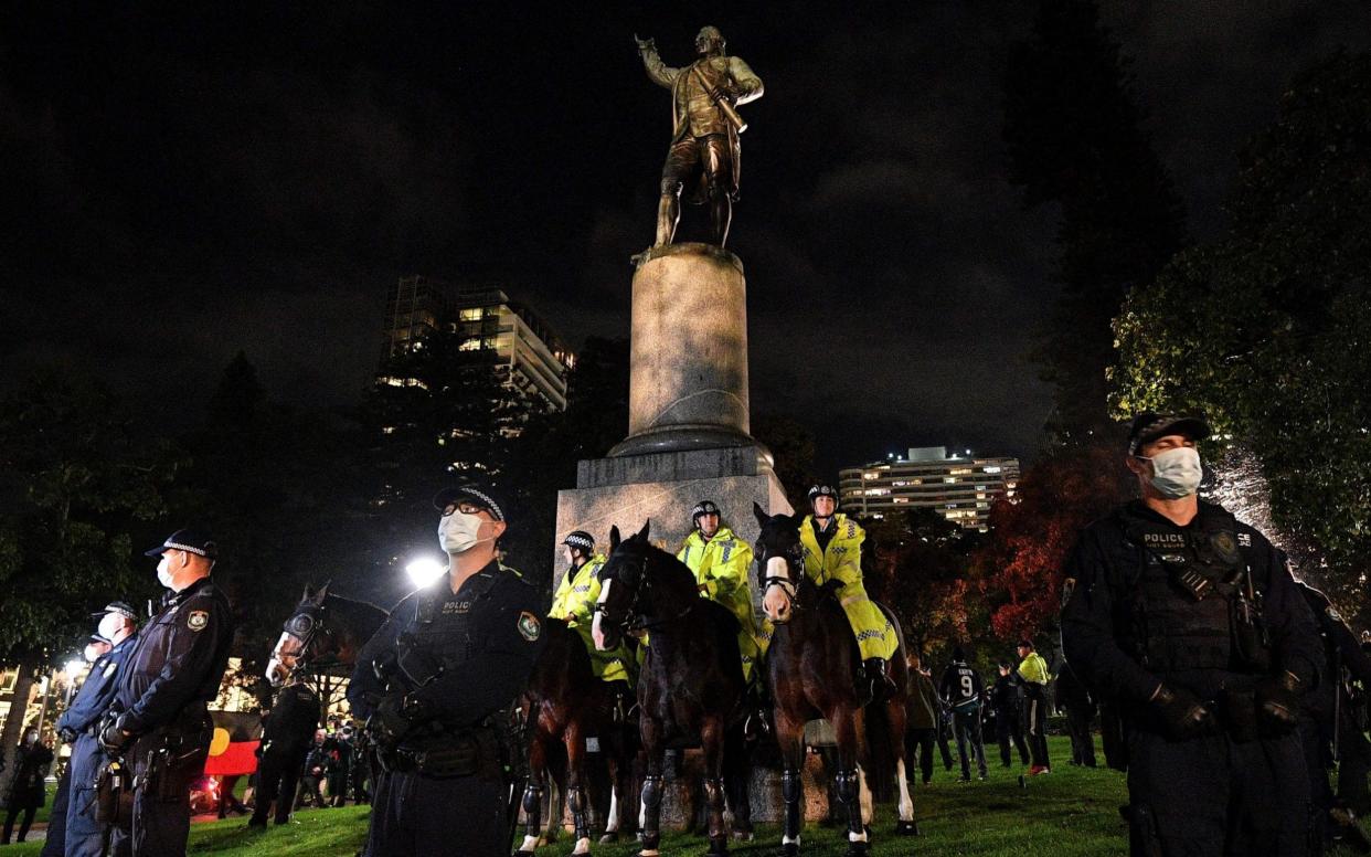 Police stand guard at the statue of Captain Cook in Hyde Park  - AFP