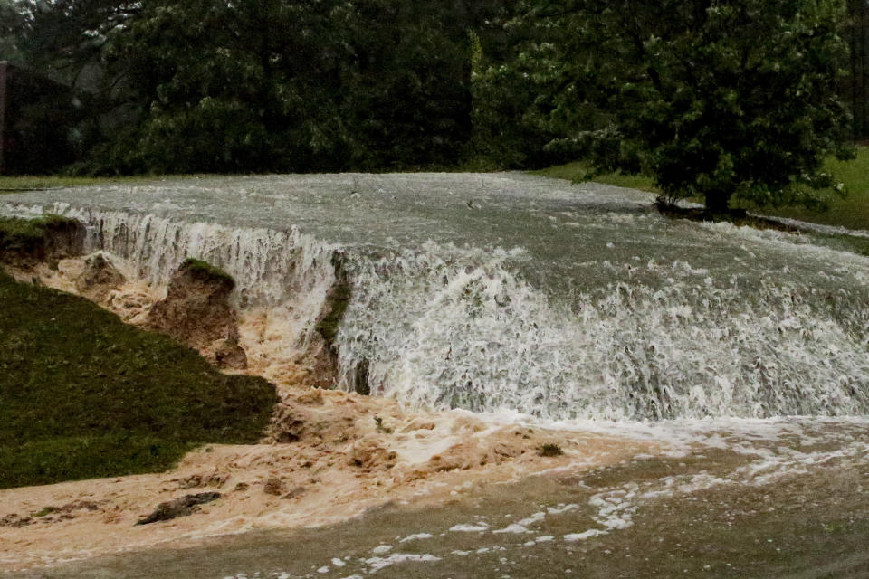 A hillside is eroded away as torrential rainfall falls Tuesday, May 4, 2021 in Vestavia, Ala. (AP Photo/Butch Dill)