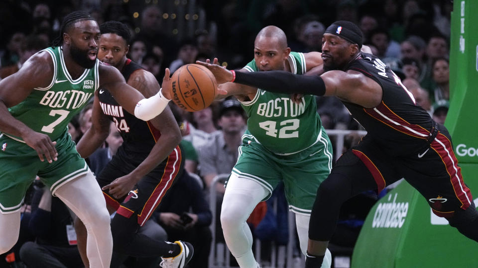 Miami Heat center Bam Adebayo, right, battles for the ball against Boston Celtics center Al Horford and guard Jaylen Brown during the first half of Game 2 of an NBA basketball first-round playoff series, Wednesday, April 24, 2024, in Boston. (AP Photo/Charles Krupa)