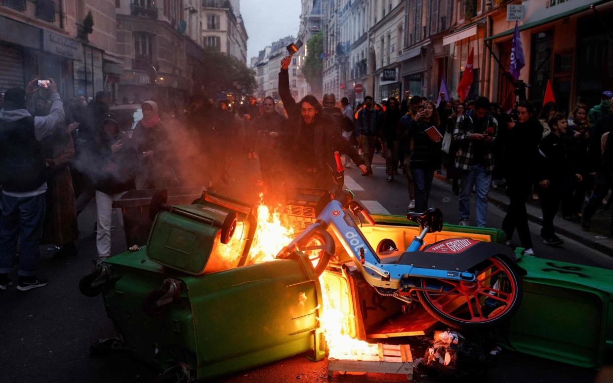 A protest in Paris during French President Emmanuel Macron's televised address to the nation after signing pension reforms into law - AFP