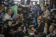 Al-Jazeera journalists Mohamed Fahmy (bottom, 3rd from R) and Baher Mohamed (center, 2nd from R), talk to the press during their trial in Cairo on August 29, 2015