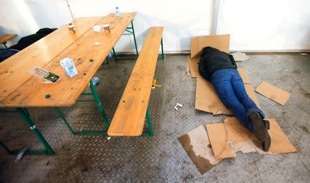 A migrant rests on cardboards at the the Berlin Office of Health and Social Affairs (LAGESO), in Berlin, Germany, January 5, 2016. REUTERS/Hannibal Hanschke