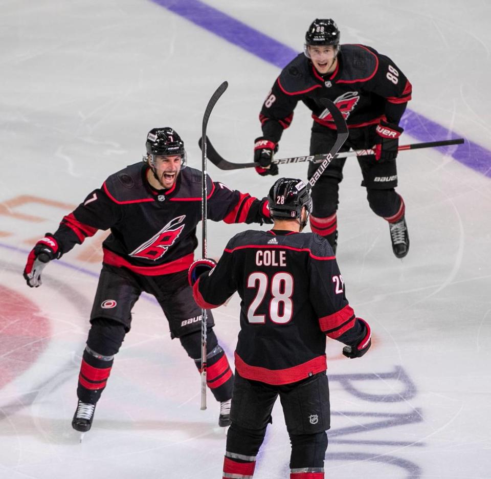 Carolina Hurricanes’ Brendan Smith (7) and Martin Necas (88) react after a game winning overtime goal by teammate Ian Cole (28) on Wednesday, May 18, 2022 during game one of the Stanley Cup second round at PNC Arena in Raleigh, N.C.