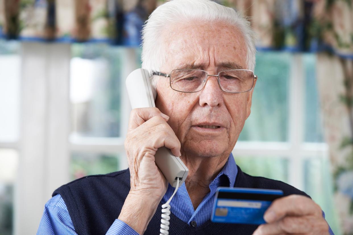 senior man giving credit card details on the phone