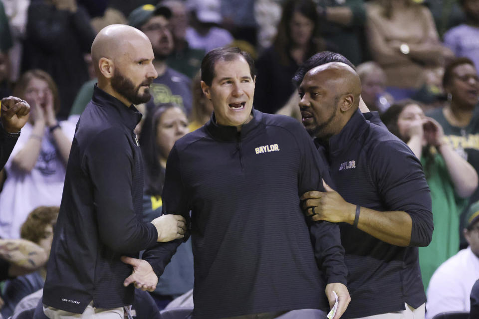 FILE - Baylor head coach Scott Drew, center, is held back by assistant coaches after reacting to a foul call in the second half of an NCAA college basketball game against Kansas State, Saturday, Jan. 7, 2023, in Waco, Texas. (AP Photo/Rod Aydelotte, File)