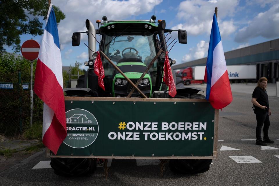 A sign reads ‘Our Farmers, Our Future’ as some 25 tractors form a blockade outside a distribution centre for supermarket chain Albert Heijn in the town of Zaandam, just north of Amsterdam (AP)