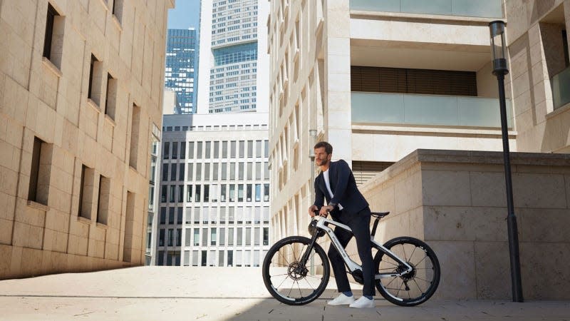 A photo of a man riding a black and white Porsche e-bike. 