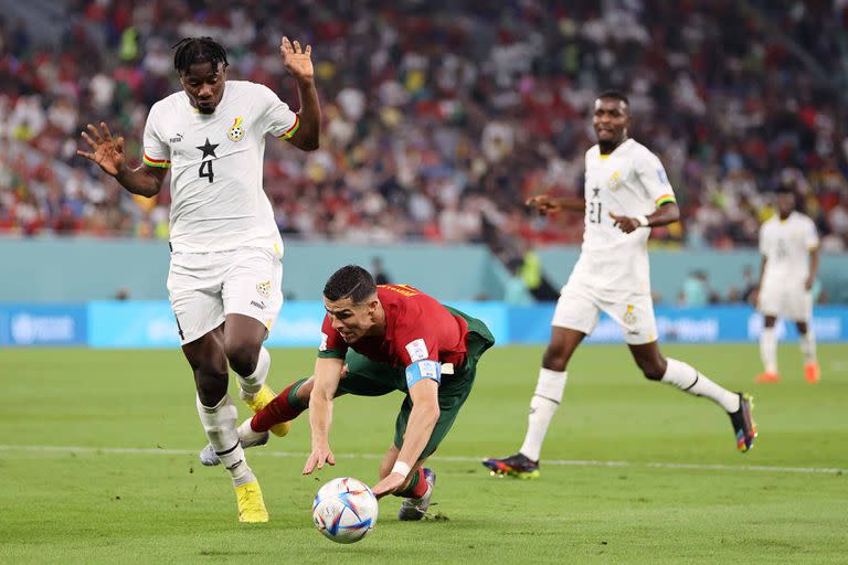 DOHA, QATAR - NOVEMBER 24: Cristiano Ronaldo of Portugal is brought down by Mohammed Salisu of Ghana during the FIFA World Cup Qatar 2022 Group H match between Portugal and Ghana at Stadium 974 on November 24, 2022 in Doha, Qatar. (Photo by Clive Brunskill/Getty Images)