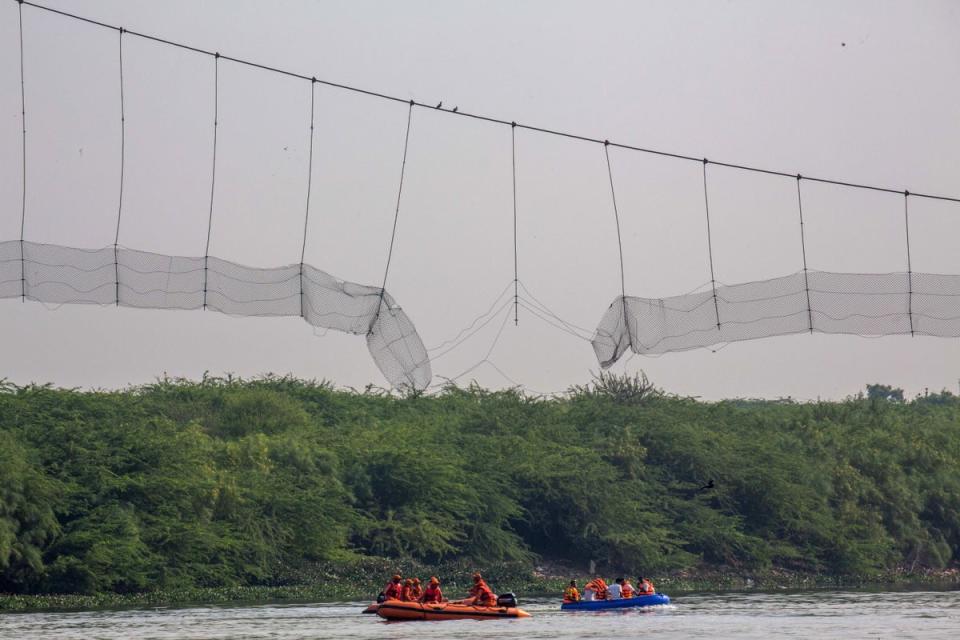 The collapsed Jhulto Pul, a pedestrian suspension bridge, during a rescue operation in Morbi (EPA)