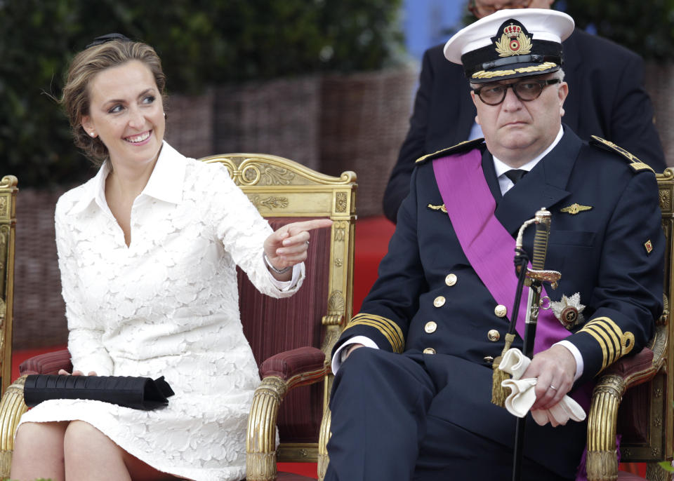 FILE - In this Monday, July 21, 2014 file photo, Belgium's Prince Laurent and his wife Claire watch a military parade on Belgian National Day, in front of the Royal Palace in Brussels. As the British royal family wrestles with the future roles of Prince Harry and his wife Meghan, it could look to Europe for examples of how princes and princesses have tried to carve out careers away from the pomp and ceremony of their families’ traditional duties. Prince Laurent, the brother of Belgium’s King Philippe, has long struggled with his royal role and obligations that come with his annual tax payer-funded endowment. (AP Photo/Yves Logghe, File)