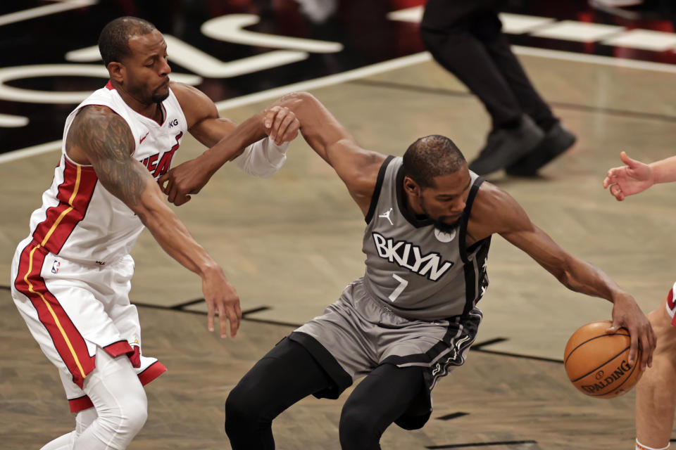 Brooklyn Nets forward Kevin Durant (7) controls the ball while defended by Miami Heat forward Andre Iguodala during the first half of an NBA basketball game Monday, Jan. 25, 2021, in New York. (AP Photo/Adam Hunger)