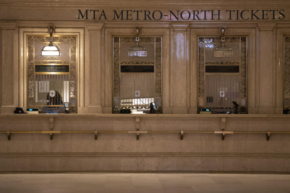 FILE - In this Tuesday, March 17, 2020 file photo, a Metro-North ticket clerk waits for customers at Grand Central Terminal in New York. The Metropolitan Transportation Authority says it is facing a "financial calamity" as ridership on subways and commuter rail lines has nose-dived as people stay home to avoid the COVID-19 coronavirus. (AP Photo/Mary Altaffer, File)