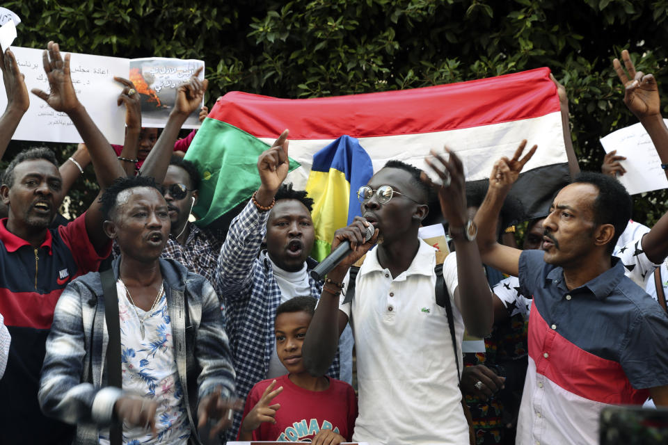 Sudanese nationals living in Lebanon chant slogans as they hold their national flag during a protest to condemn a military coup earlier this week, in front of the Sudanese Embassy in Beirut, Lebanon, Saturday, Oct. 30, 2021. The United Nations and the United States urged Sudan's top generals to allow pro-democracy protests Saturday and avoid confrontations in the wake of a military coup earlier this week. (AP Photo/Bilal Hussein)