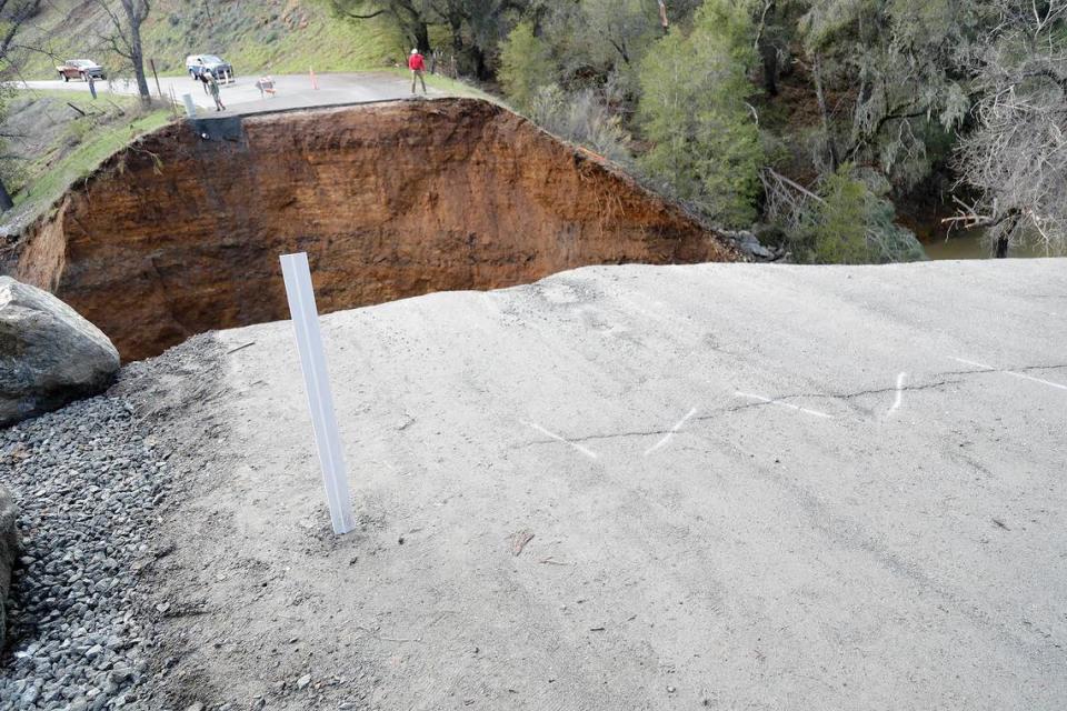 A man assesses the damage at Chimney Rock Road northwest of Paso Robles on Saturday, March 11, 2023. A section of the road washed out a recent rain storm to hit San Luis Obispo County, stranding about 100 residents.