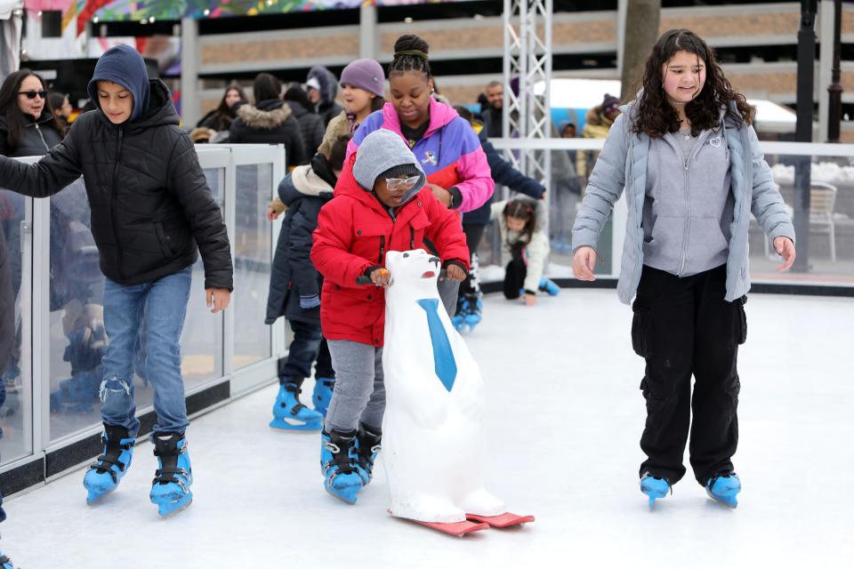 Six-year-old Nazhyre Browning, center, of New Rochelle, with his mother Saundra Browning behind him, skates during the Winter Carnival kick-off event for the outdoor skating rink in Lincoln Park in New Rochelle Feb. 21 2024. The event was organized by the city council, the City of New Rochelle and the New Rochelle Community Justice Center. The rink is free to use and is open from noon to 7 p.m. daily until Saturday, Feb. 24.