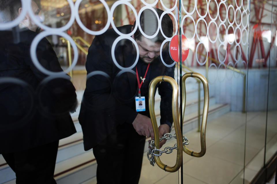 Tropicana security chain up the doors after the closing of the historic property at the Tropicana hotel-casino, Tuesday, April 2, 2024, in Las Vegas. The hotel-casino is slated for demolition in October to make room for a $1.5 billion baseball stadium. (AP Photo/John Locher)