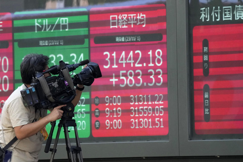 A cameraman films electronic stock board showing Japan's Nikkei 225 index, seen in red, at a securities firm Wednesday, Nov. 1, 2023 in Tokyo. Asian shares were mostly higher Wednesday after Wall Street advanced to claim back some of the ground it gave up in another losing month. (AP Photo/Shuji Kajiyama)