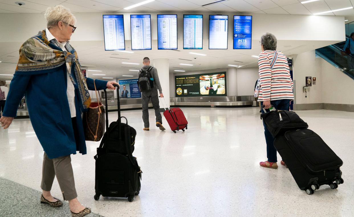 Airport travelers move around the Nashville International Airport without face coverings Wednesday, April 20, 2022 in Nashville, Tenn. after a recent federal judge's decision to strike down a national mask mandate.