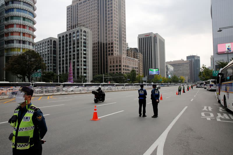 South Korean police stand guard near police buses that are parked surrounding the Gwanghwamun square to prevent unexpected anti-government protests amid the coronavirus disease (COVID-19) pandemic in central Seoul