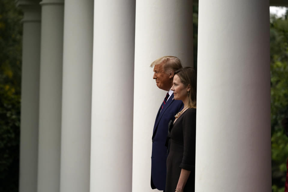 President Donald Trump walks with Judge Amy Coney Barrett to a news conference to announce Barrett as his nominee to the Supreme Court, in the Rose Garden at the White House, Saturday, Sept. 26, 2020, in Washington. (AP Photo/Alex Brandon)