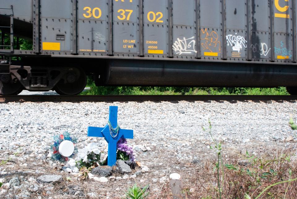 A CSX train passes by a trackside memorial for Freeda Pruitt who was killed at a private railroad crossing in Lanexa, Virginia.