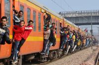 Commuters travel in an overcrowded train near a railway station in Ghaziabad, on the outskirts of New Delhi