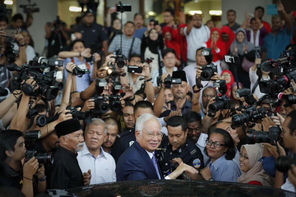 FILE - In this April 3, 2019, file photo, former Prime Minister Najib Razak, center, gets into a car after his court appearance at the Kuala Lumpur High Court in Kuala Lumpur, Malaysia. After years of insisting on his innocence, Najib learns his fate this week in his first corruption trial linked to one of the world’s biggest financial scandals - a verdict widely seen as a test for the rule of law five months after a new government took power. July 28, 2020's ruling is being closely watched amid a stunning reversal of fortune for Najib’s Malay party, which returned to office as a key player in the new ruling alliance. (AP Photo/Vincent Thian, File)