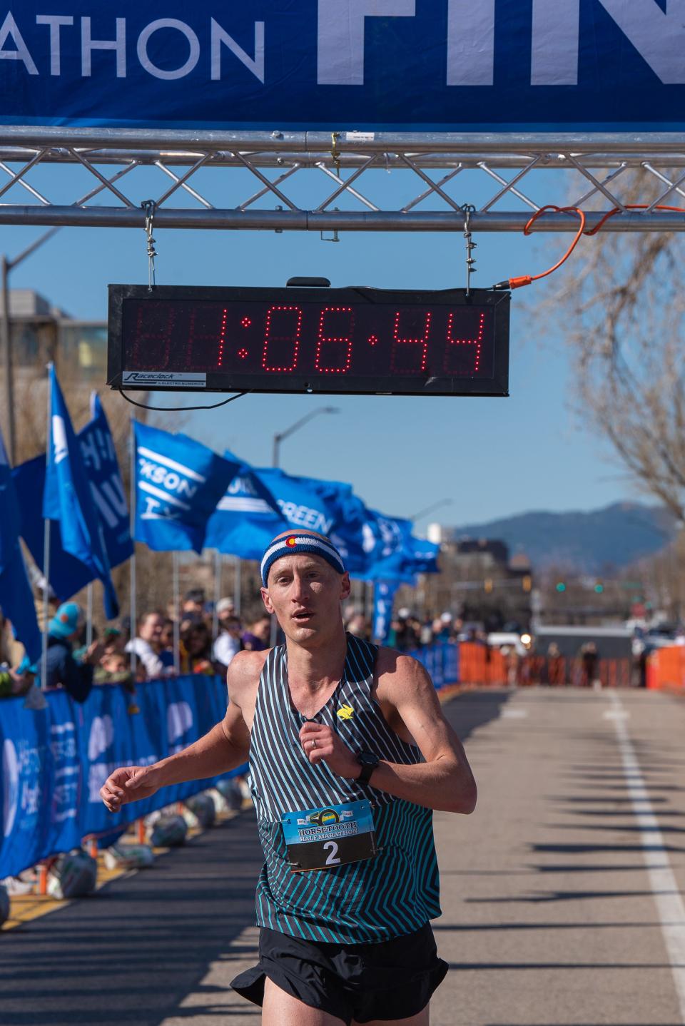 Second-place finisher Tyler McCandless crosses the finish line of the 50th Horsetooth Half Marathon on Sunday in Fort Collins.