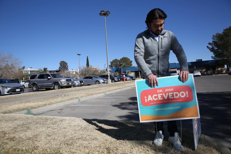 District 2 City Council candidate Josh Acevedo arranges one of his political signs outside a polling place during early voting on Jan. 5, 2024.