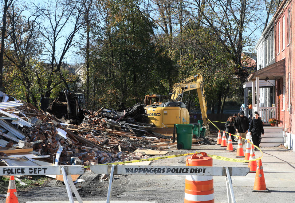 Residents of the adjacent residences on Brick Row walk passed the rubble pile on November 3, 2023. The 4 unit building was demolished following a gas main explosion and subsequent fire that destroyed much of the structure.