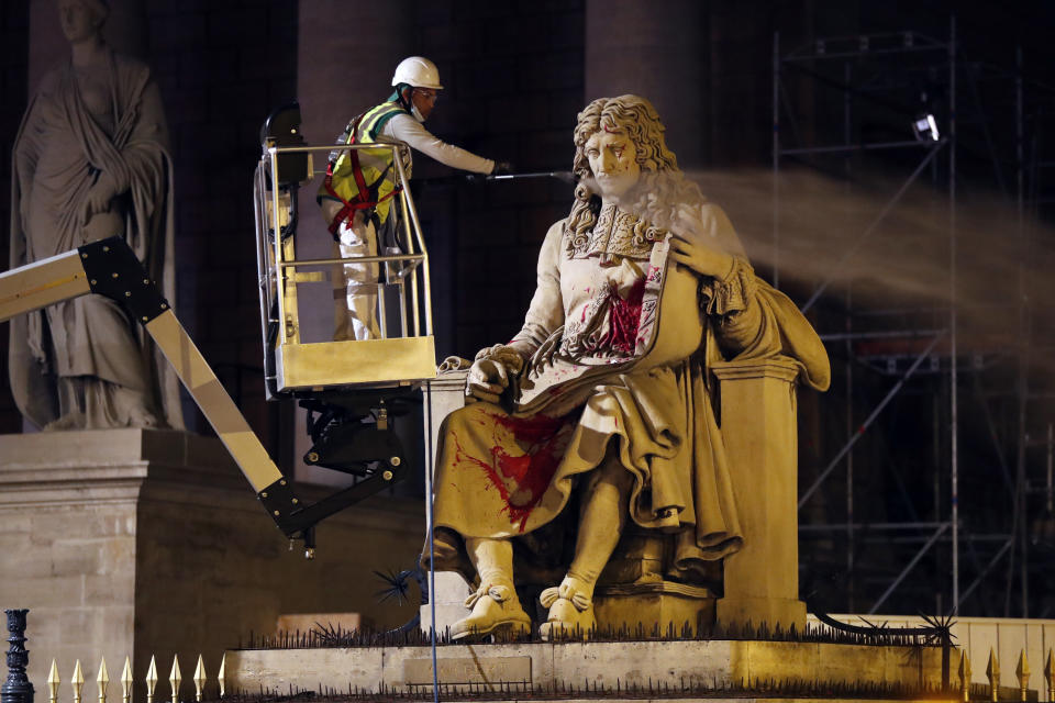 FILE - In this June 23, 2020 file photo, a worker from Paris' City Hall cleans the statue of Jean-Baptiste Colbert, in front of the National Assembly in Paris, after a French activist for Black rights defaced the statue of the historical figure from France's colonial, slave-trading past. France's highest court has rejected a request by three groups seeking reparations for slavery in a case that originated on the French Caribbean island of Martinique. The court's decision on Wednesday July 5, 2023 said no individual produced evidence showing they had "suffered individually" any damage from the crimes that their ancestors had been subjected to. (AP Photo/Thibault Camus, File)