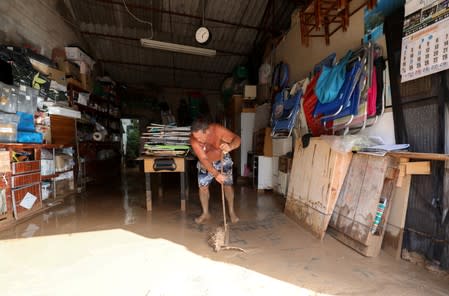 A man cleans his garage after heavy rains in Los Alcazeres