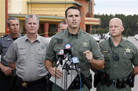 Pasco County Sheriff Chris Nocco (C) speaks to the media as police tape surrounds the Cobb Grove 16 movie theater in Wesley Chapel, Florida, January 13, 2014. REUTERS/Mike Carlson