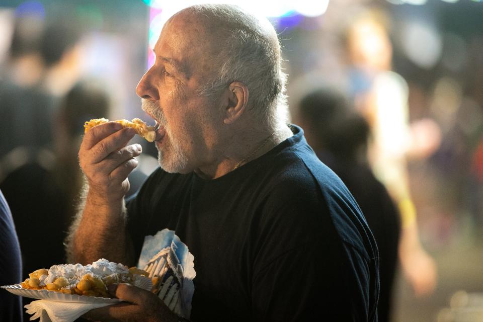 Angelo Petrakis enjoys funnel cake at the Stripes Carnival at Buc Days on Friday, May 12, 2023.