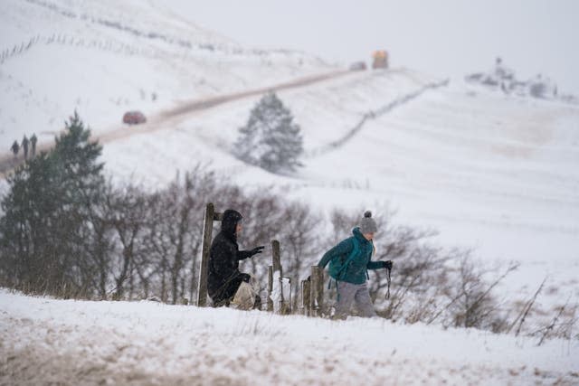 Walkers cross a field covered in snow