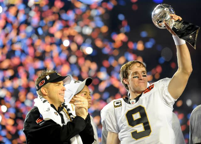 <p>Rob Tringali/Sportschrome/Getty</p> Drew Brees holds up the Vince Lombardi Trophy alongside coach Sean Payton following the New Orleans Saints' 2010 Super Bowl win