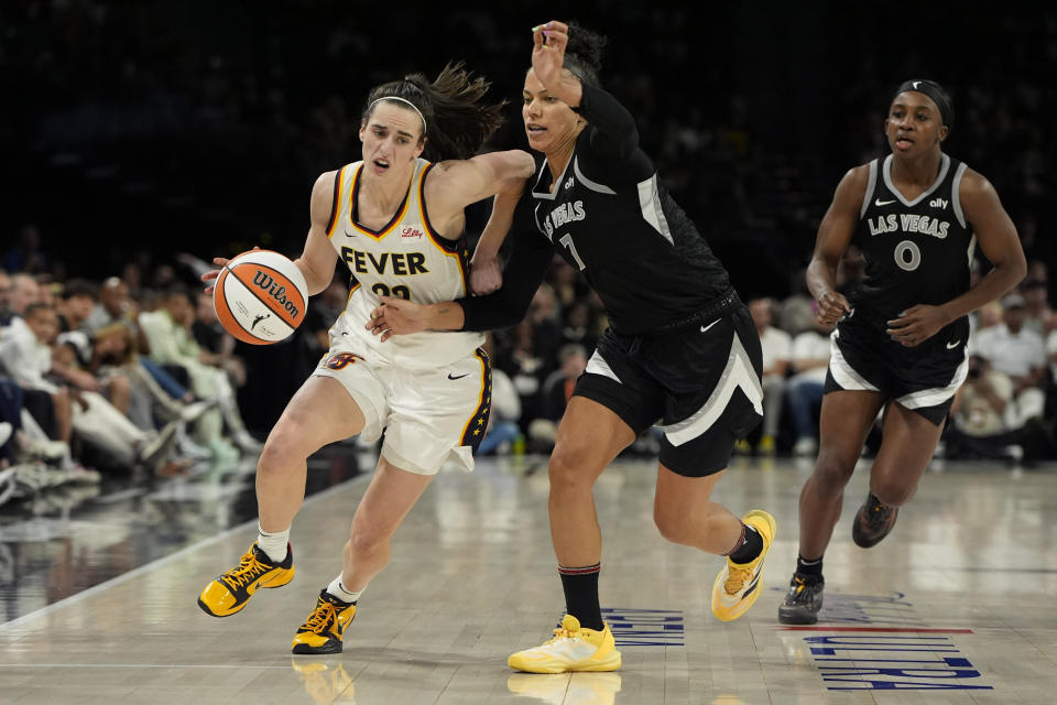 Indiana Fever guard Caitlin Clark (22) drives against Las Vegas Aces forward Alysha Clark (7) during the second half of a WNBA basketball game Saturday, May 25, 2024, in Las Vegas. (AP Photo/John Locher)