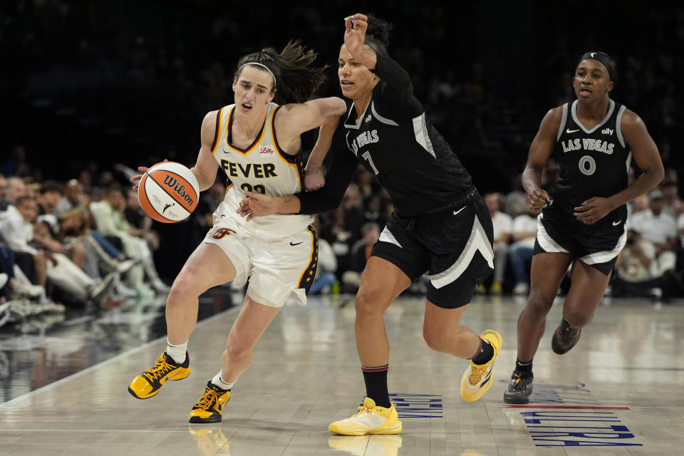 Indiana Fever-bewaker Caitlin Clark (22) rijdt tegen Las Vegas Aces-aanvaller Alysha Clark (7) tijdens de tweede helft van een WNBA-basketbalwedstrijd op zaterdag 25 mei 2024 in Las Vegas.  (AP-foto/John Locher)