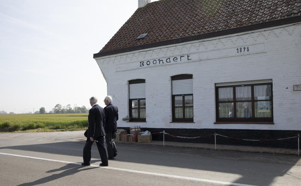 British RAF veteran George Sutherland, 98, left, walks by his childhood home with his son Alex Sutherland as he takes part in a VE Day charity walk to raise funds for Talbot House in Poperinge, Belgium, Friday, May 8, 2020. Sutherland walked from the Lijssenthoek war cemetery to Talbot house to raise money for the club which is currently closed due to coronavirus lockdown regulations. The club, founded in 1915 was a place for British soldiers to rest during both the First and Second World Wars. (AP Photo/Virginia Mayo)