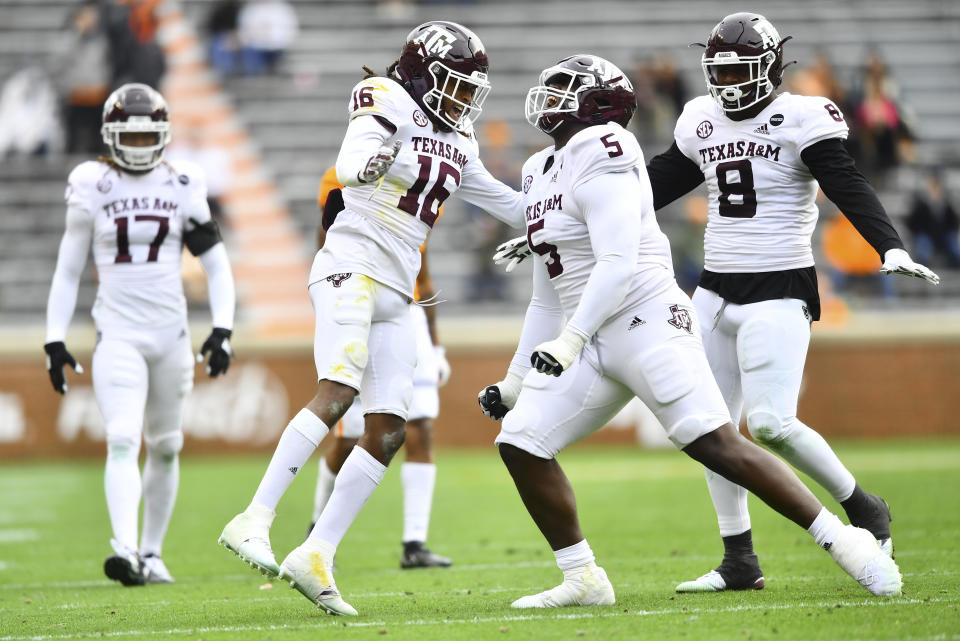 Texas A&M defensive back Brian George (16), and defensive linemen Bobby Brown III and DeMarvin Leal (8) celebrate against Tennessee during an NCAA college football game in Neyland Stadium in Knoxville, Tenn., Saturday, Dec. 19, 2020. (Brianna Paciorka/Knoxville News Sentinel via AP, Pool)