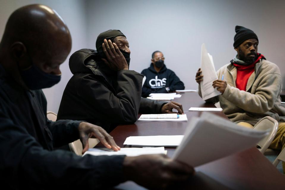 Michael Howard, 61, left, Harry Simpson, 59, Johnnie B. Tingle, 53, a permanent housing case manager, and Kyle Smith, 48, listen during a housing voucher meeting at RPI Management, Inc. in Dearborn on Jan. 20, 2023.