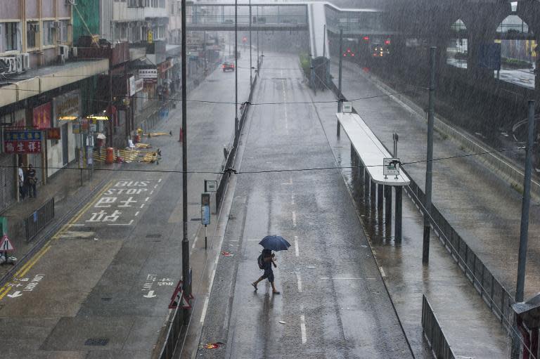 A man walks under the rain in the Sheung Wan district of Hong Kong during a thunderstorm caused by Typhoon Kalmaegi on September 16, 2014