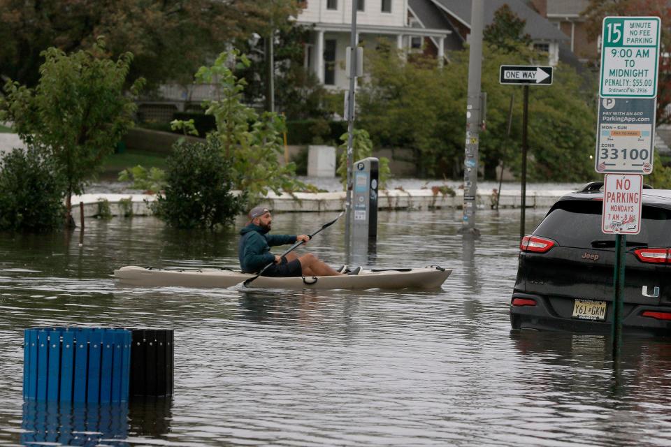 A kayaker paddles over Lake Avenue in Asbury Park, NJ, Friday afternoon, September 29, 2023, after heavy rains caused Wesley Lake to overflow its banks.