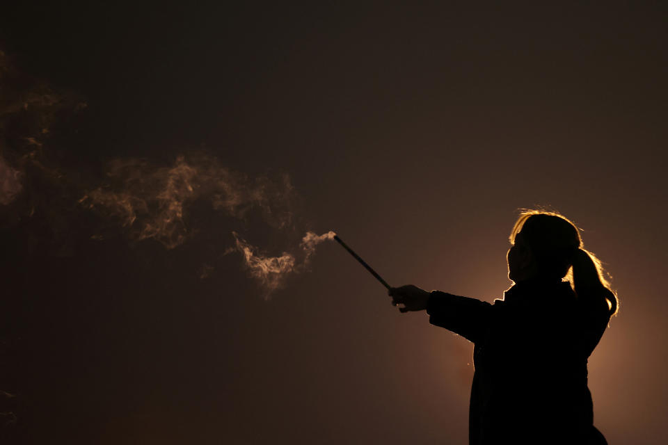 An Iranian woman lights a firework during a celebration at a park in Tehran in March.  