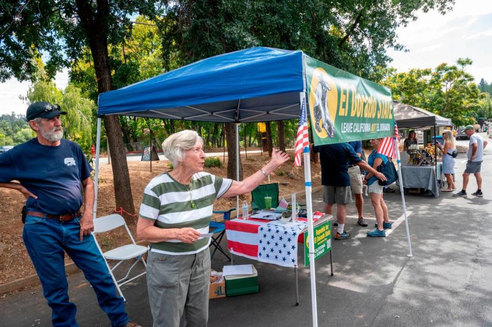Sharon Durst, leader of the secessionist El Dorado state movement, waves to people at the group’s booth set up in a parking lot in Placerville on Sept. 13.