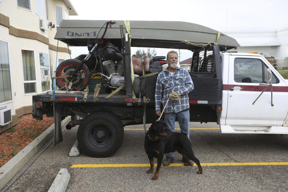 Evacuee Joe Kumleben, of Hay River, N.W.T., stands outside a hotel in Peace River, Alta., with his truck packed with his belongings after fleeing the wildfires in his area, Friday, Aug. 18, 2023. (Jason Franson /The Canadian Press via AP)