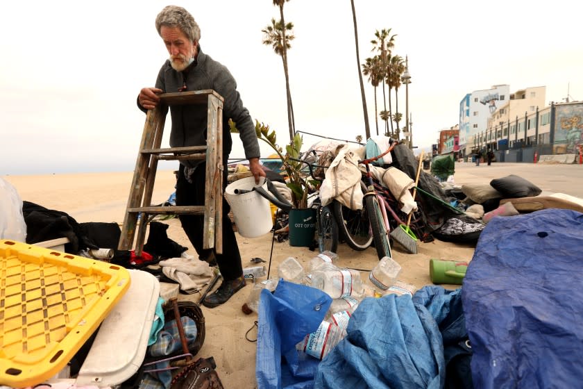 Tom Otterbach, 66, gathers his belongings along Ocean Front Walk in Venice May 18, 2021.