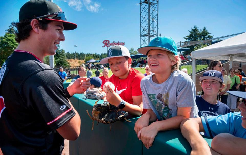 Former Gig Harbor standout Michael Toglia - now a first baseman/outfielder with the AAA Albuquerque Isotopes - talks with Hunter Ramos (center), AJ Perkins and other members of the Gig Harbor Narrows select baseball team as he returns to the Pacific Northwest for a six-game series against the Tacoma Rainiers at Cheney Stadium in Tacoma, Washington on Tuesday, Aug. 16, 2022. Toglia played for the Narrows team when he was a little leaguer.