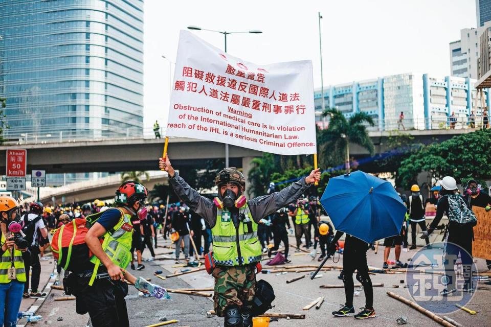 義務救護員有時也遭警察武力波及。圖為一名救護員高舉標語向警察抗議。