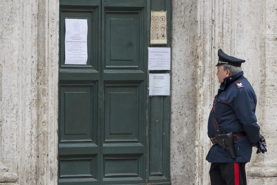 A Carabinieri (Italian paramilitary police) officers stands in front of the St. Louis of the French church in Rome, Sunday, March 1, 2020. The French community church in Rome, St. Louis of the French, closed its doors to the public on Sunday, reportedly after a priest was infected with a new virus. The church in the historic center of Rome is famous for three paintings by the Baroque master Caravaggio, and is a tourist draw. A sign on the door Sunday noted in French that the church had been closed as a precaution by the French Embassy for both Masses and touristic visits until further notice. (AP Photo/Andrew Medichini)
